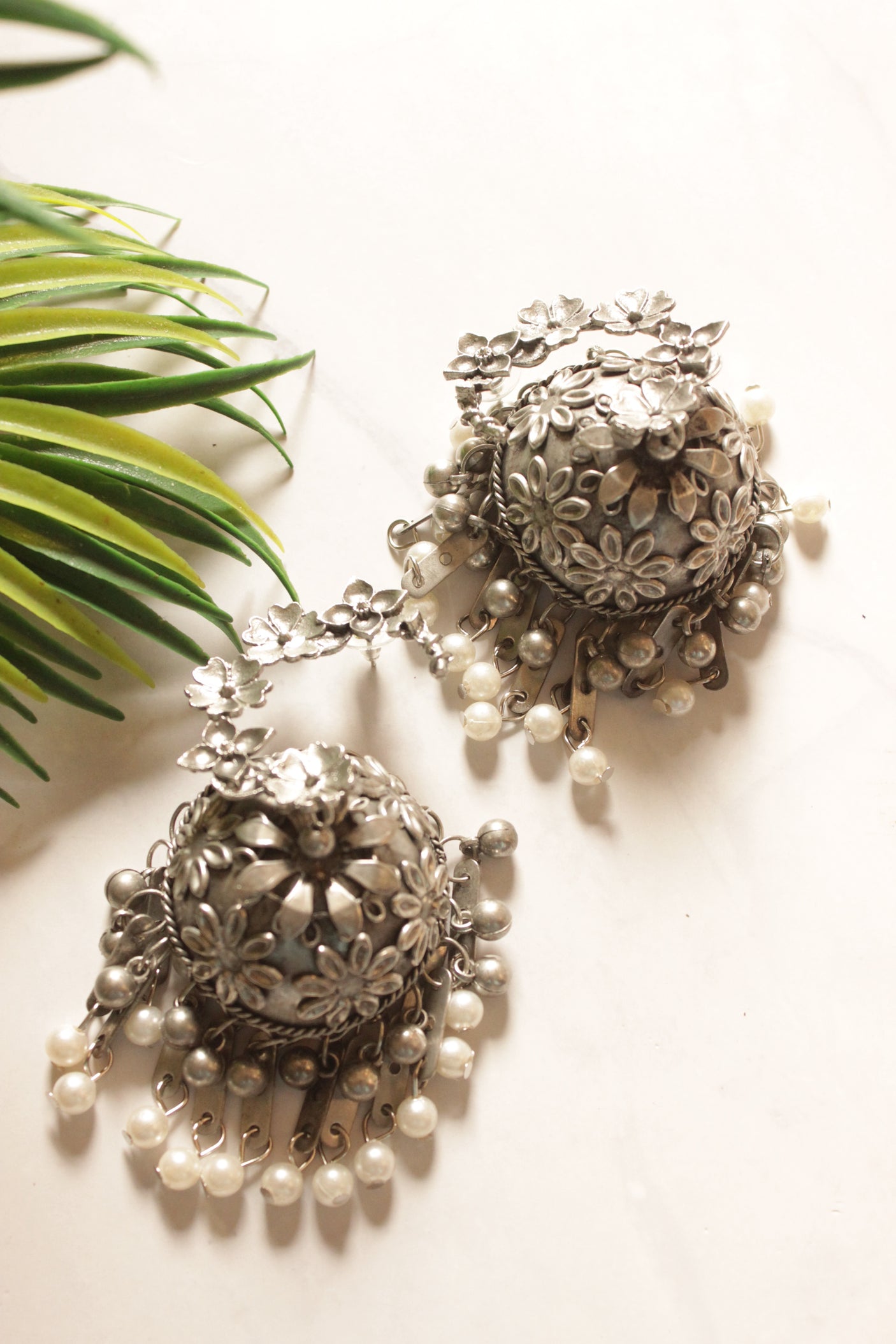 Oxidised Finish Flower Embossed Jhumka Earrings with White Beads