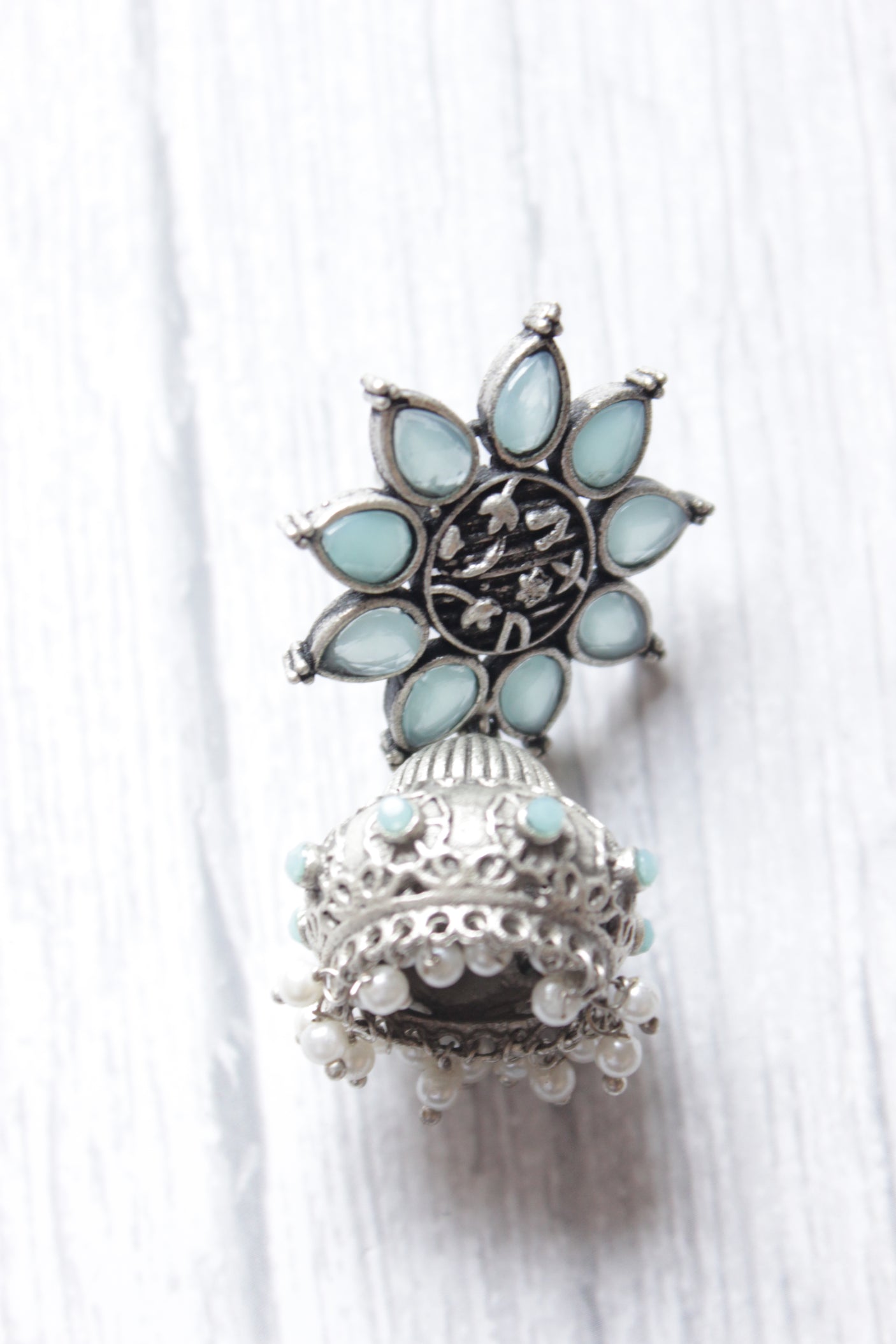 Turquoise Glass Stones Embedded Silver Finish Flower Motif Dangler Jhumka Earrings in Brass